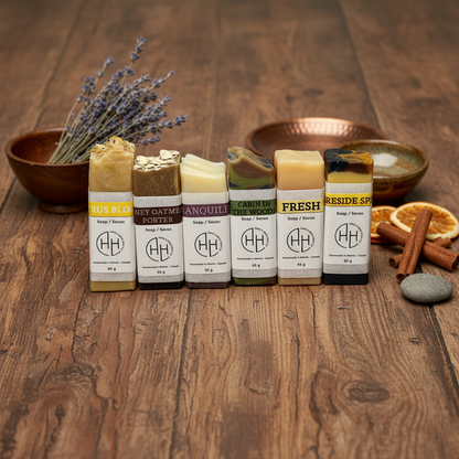 Assorted handcrafted soap bars displayed upright on wooden surface with lavender and dried citrus